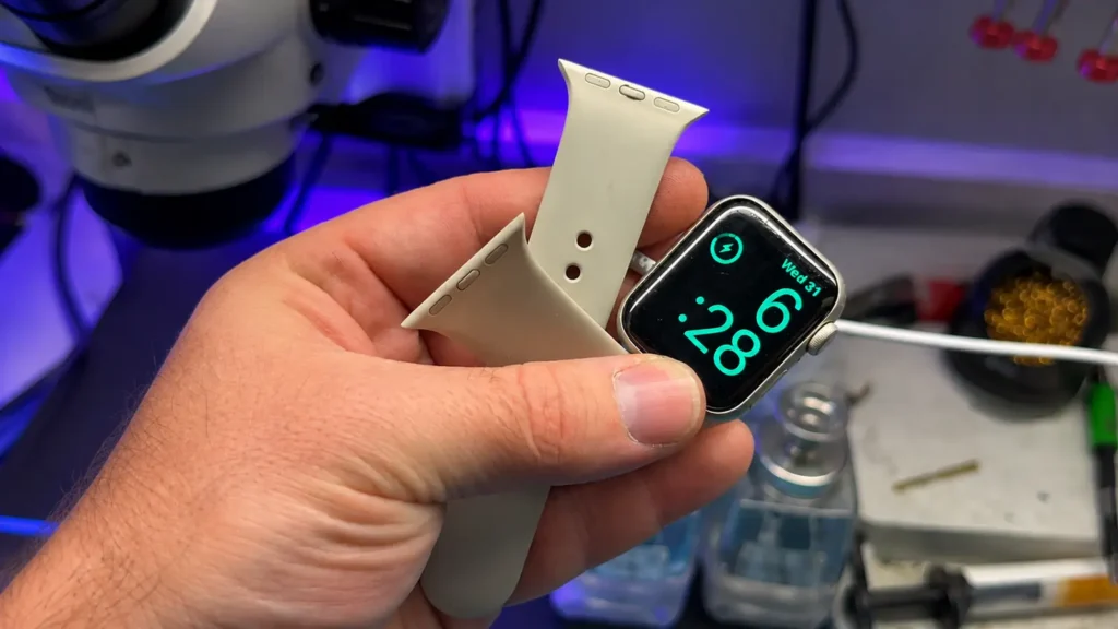 Technician holding an Apple Watch during a repair inspection.
